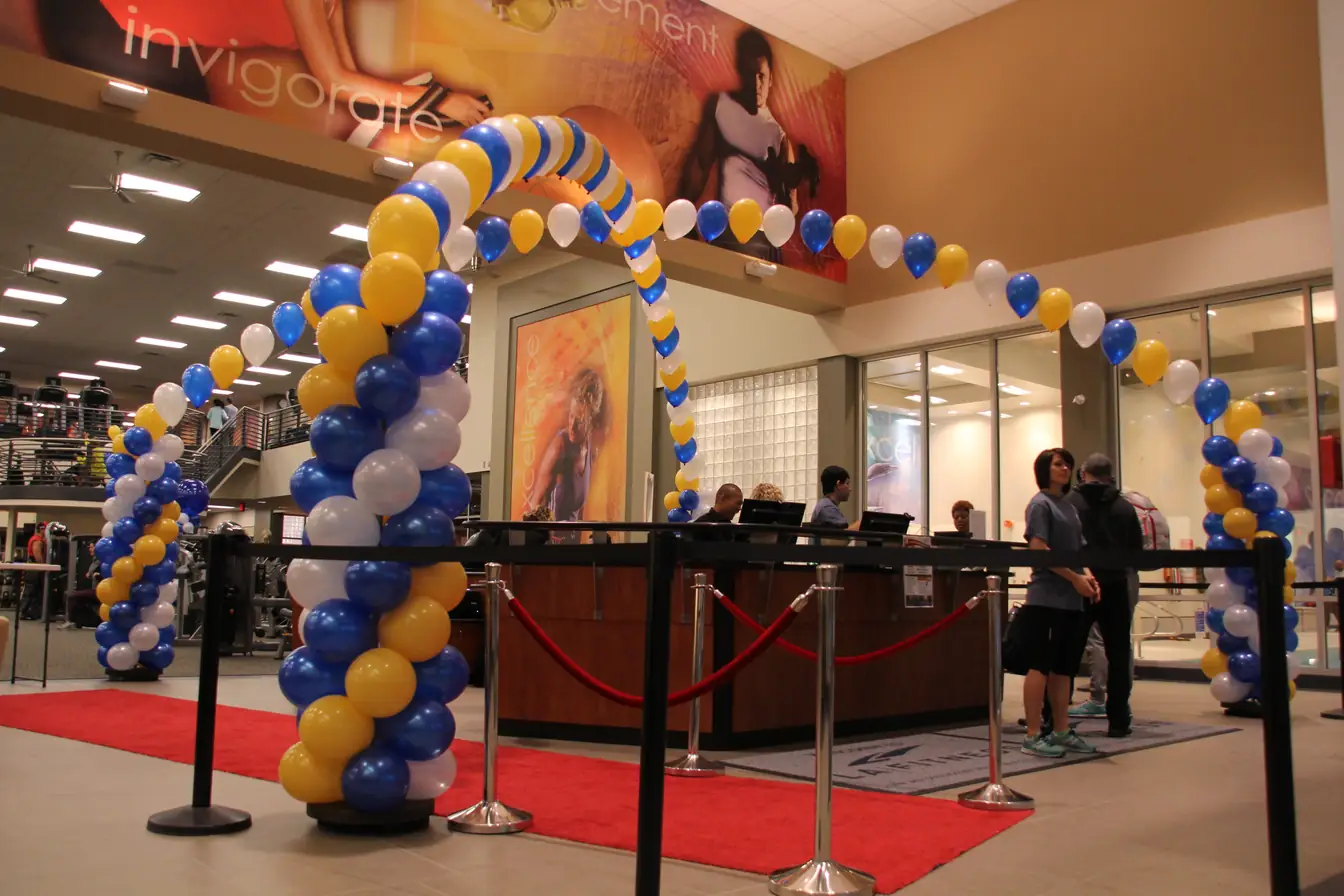 Blue and gold spiral balloon arch over a red-carpet entrance
