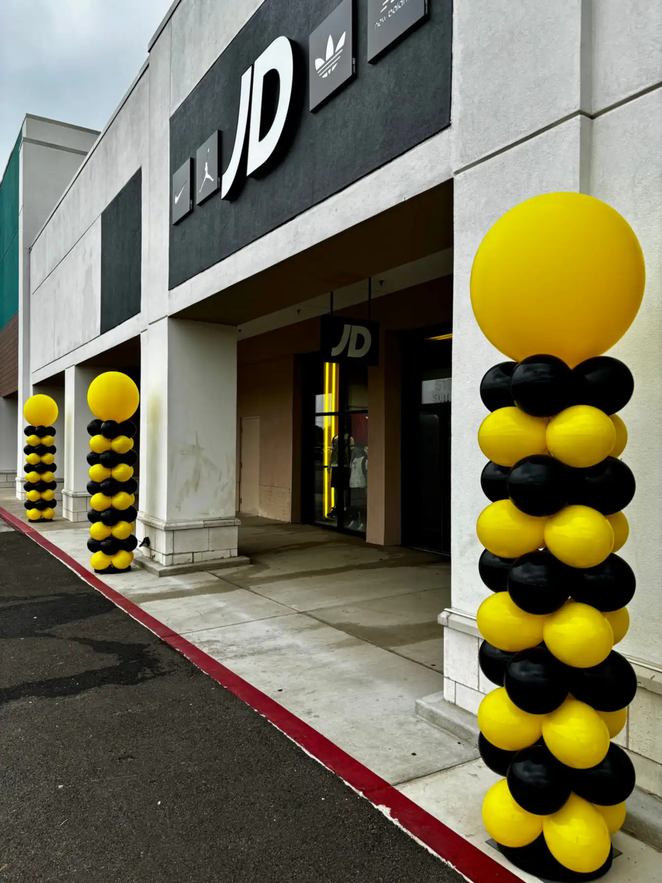 Yellow and black balloon columns at a shop entrance